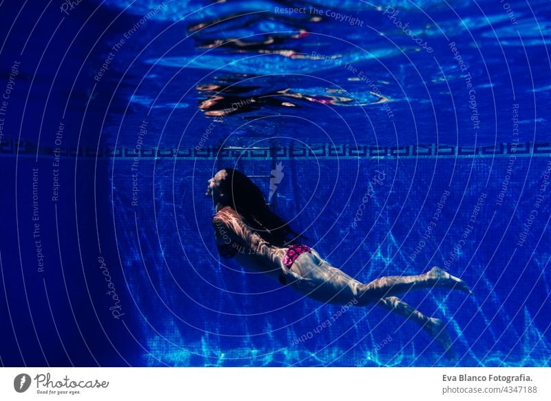 glückliche kaukasische Frau Tauchen im Schwimmbad. Unterwasser-Ansicht. Sommerzeit und Urlaub Konzept unter Wasser Spaß Liebe Blauwasser sonniger Tag im Freien