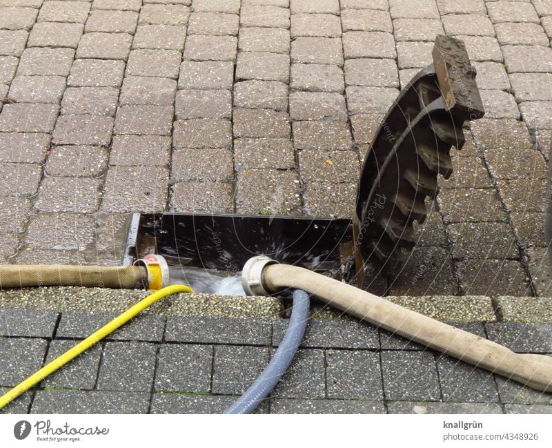 Hochwasserschäden Wasser Schlauch Kanalisation Wasserschlauch abpumpen Wasserschaden abfließen Gully Gullydeckel hochgeklappt Straße Bürgersteig