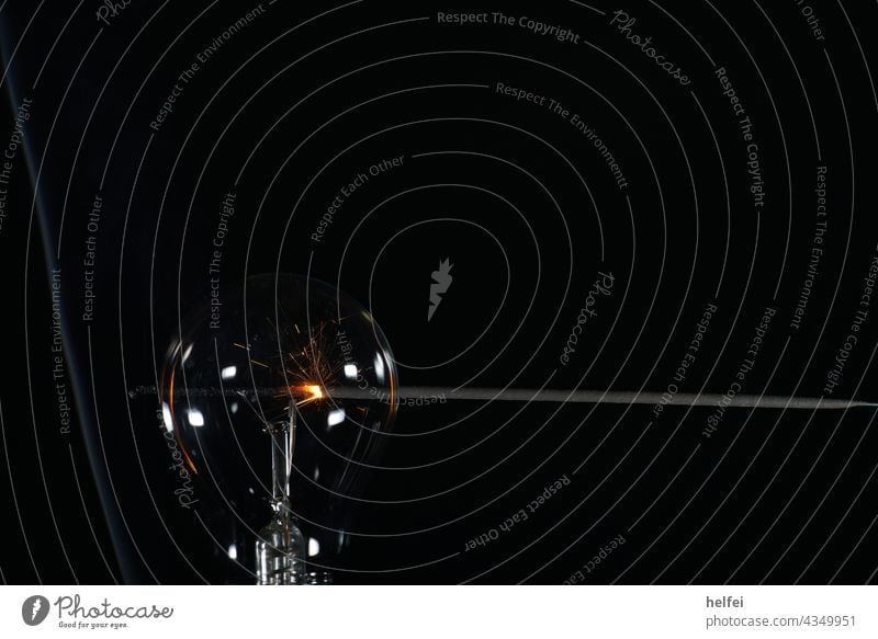 Durchsichtige Glühbirne mit Sternenwerfer im Hintergrund mit Schwarzem Hintergrund und aufsteigenden Rauch Technik & Technologie Lampe Licht Elektrizität Glas