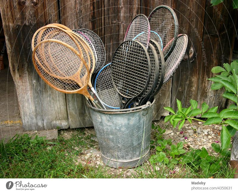 Badminton Schläger in allen Varianten in einem alten Zinkeimer vor einer alten Scheune auf einem Bauernhof in Rudersau bei Rottenbuch im Kreis Weilheim-Schongau in Oberbayern