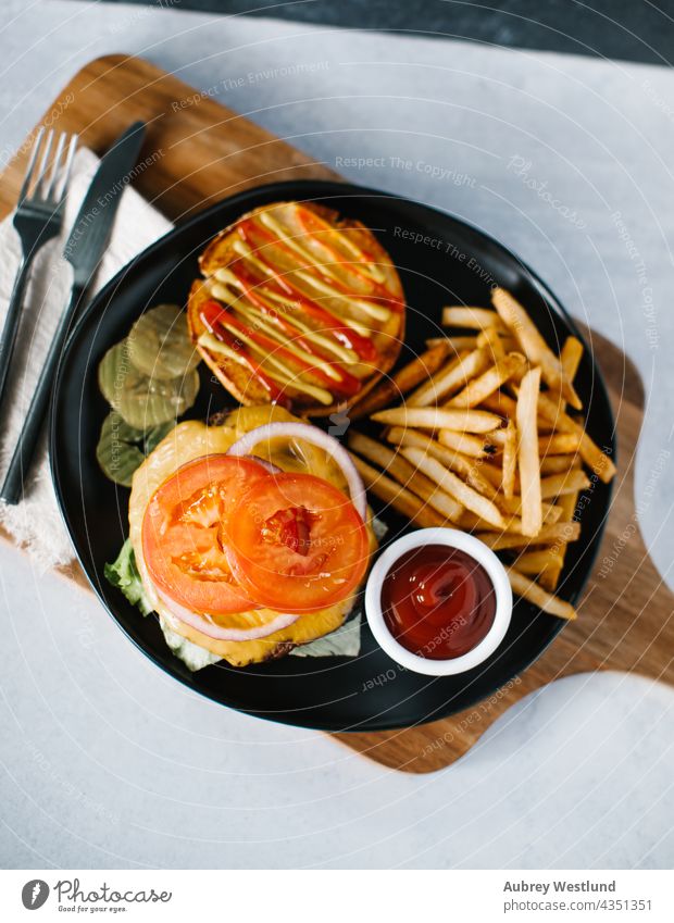 Traditioneller amerikanischer Cheeseburger mit Pommes frites Amerikaner Hintergrund Barbecue grillen Rindfleisch groß Brot Brötchen Burger Cheddar Käse Küche