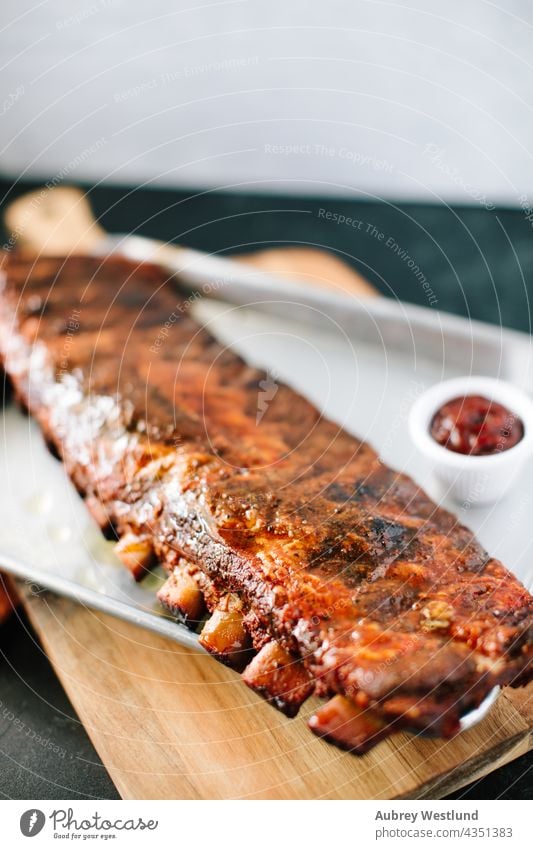 Rack of Ribs in Barbecue-Soße Amerikaner Hintergrund gebacken gegrillt grillen Rindfleisch Holzplatte Knochen Holzkohle Nahaufnahme gekocht Essen zubereiten