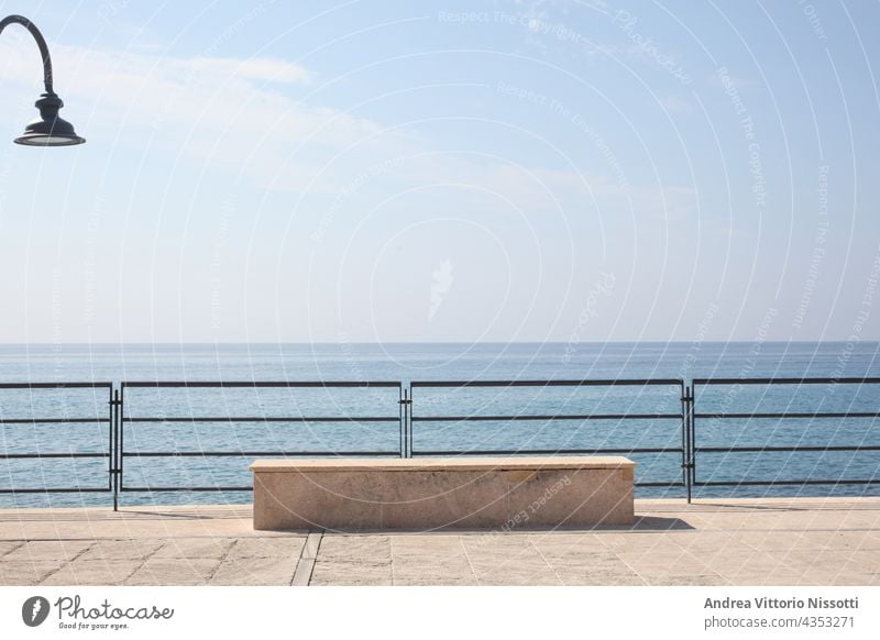 Steinbank auf einer Seebrücke an der italienischen Küste im Morgenlicht horizontal im Freien Farbbild farbenfroh niemand keine Menschen Himmel blau Hintergrund