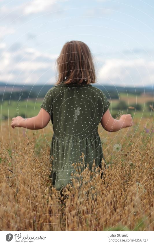 kleines Mädchen läuft mit geöffneten Armen durch ein Haferfeld haferfeld Körner Ähren hochsommer reif Kleid gepunktet kurze haare Rhön Natur alleine laufen