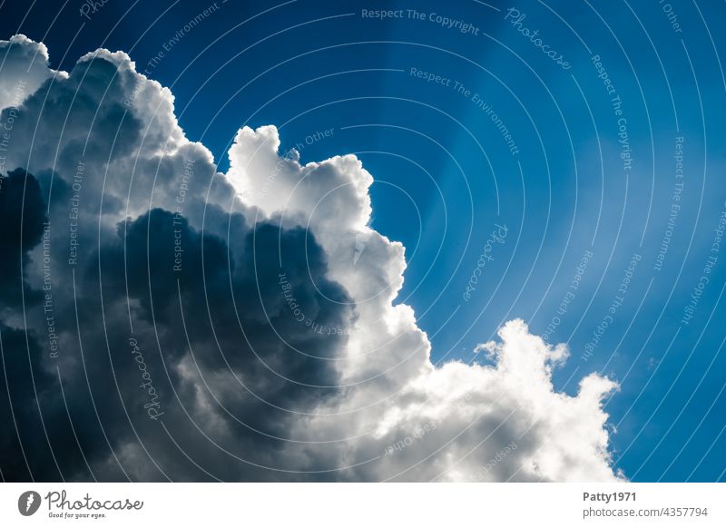 Sonnenstrahlen scheinen hinter dramatischen Wolken hervor Himmel Blauer Himmel Außenaufnahme Sommer Sonnenlicht Menschenleer Schönes Wetter blau Freiheit Weite