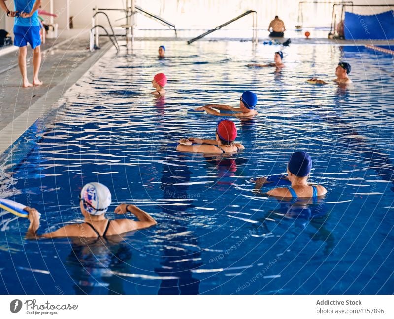 Gesellschaft von Menschen, die mit Wassernudeln bei der Wassergymnastik trainieren Aerobic schwimmen Kickboards Training Übung Menschengruppe aqua Trainerin