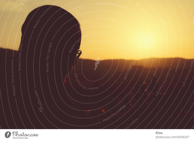 Silhouette eines Männergesichtes bei Sonnenuntergang Mann Gesicht Profil Gegenlicht Schatten Kopf nachdenklich Mensch Licht Kontrast warm Landschaft