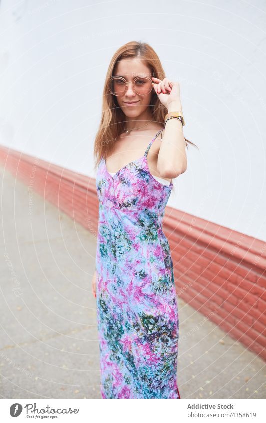 Lächelnde Frau mit Sonnenbrille und Kleid in der Stadt Sommer Stil Straße Großstadt Mode trendy heiter urban Inhalt Optimist froh Glück Outfit sorgenfrei Freude