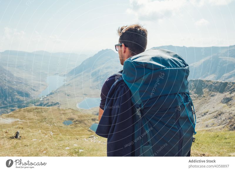 Männlicher Rucksacktourist in den Bergen am sonnigen Tag stehend Mann Wanderer Berge u. Gebirge Hochland Reisender Trekking Abenteuer Wanderung männlich Wales