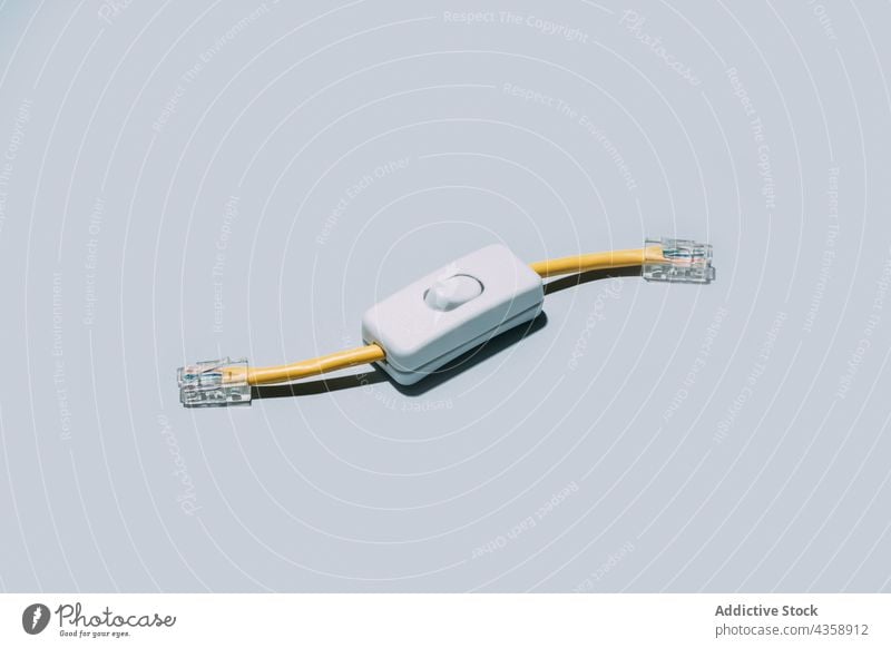 Netzwerkkabel mit Umschalttaste isoliert auf grauem Hintergrund Schalter Schaltfläche Kabel Anschluss Licht Technik & Technologie vereinzelt drehen. aus Energie