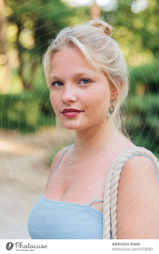 Junge Frau im Sommerpark stehend Park sonnig charmant Schönheit Vorschein schön Lächeln Sonnenlicht positiv hübsch tausendjährig jung Natur Glück blond Freude