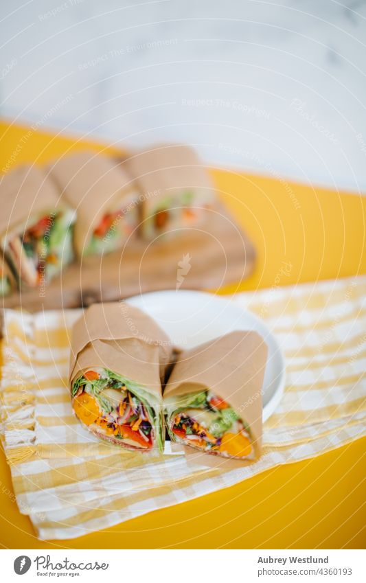 Salatwickel auf gelbem Hintergrund umhüllen Belegtes Brot Tomate kein Brot Glutengehalt Lebensmittel Gemüse Snack lecker rollen Burger Mahlzeit Fleisch