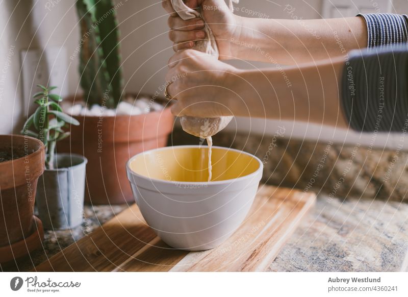 Frau bei der Herstellung von Cashew-Milch Blogger blau Cashewnuss Cashewnüsse Kaffee Koch Essen zubereiten Milchkännchen essen Lebensmittel Gesundheit heimwärts