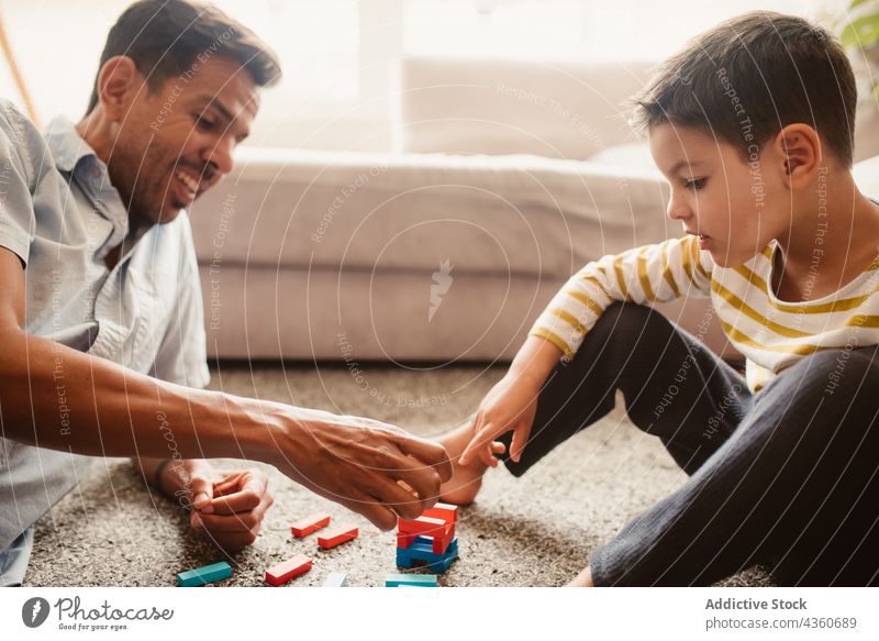 Vater und Sohn spielen mit Bausteinen im Esszimmer Kind Klotz Zusammensein Spielzeug Junge Familie Mann Kindheit Konstruktion Bildung Lächeln bauen Spielfigur