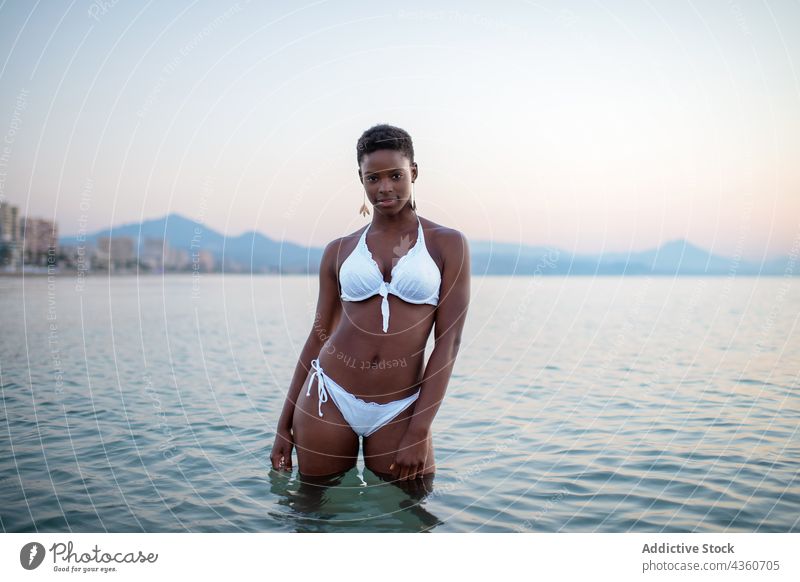 Schwarze Frau mit kurzen Haaren im Meer MEER Wasser Sonnenuntergang Rippeln Abend Sommer ethnisch schwarz Afroamerikaner ruhig schön sich[Akk] entspannen