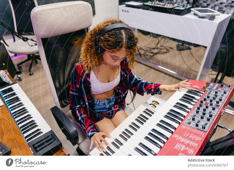 Schwarzer Sänger spielt Synthesizer und singt in ein Mikrofon im Studio Sängerin singen Gesang spielen Headset Frau Atelier benutzend Apparatur Gerät Musik