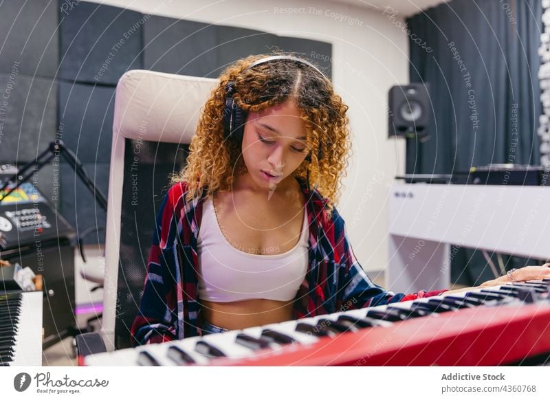 Schwarzer Sänger spielt Synthesizer und singt in ein Mikrofon im Studio Sängerin singen Gesang spielen Headset Frau Atelier benutzend Apparatur Gerät Musik