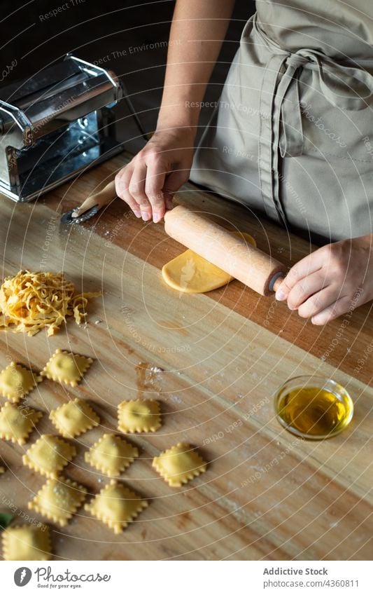 Anonyme Person bei der Zubereitung von hausgemachten Raviolis Lebensmittel Essen zubereiten Tisch Vorbereitung Küchenchef Mehl selbstgemacht hölzern Teigwaren