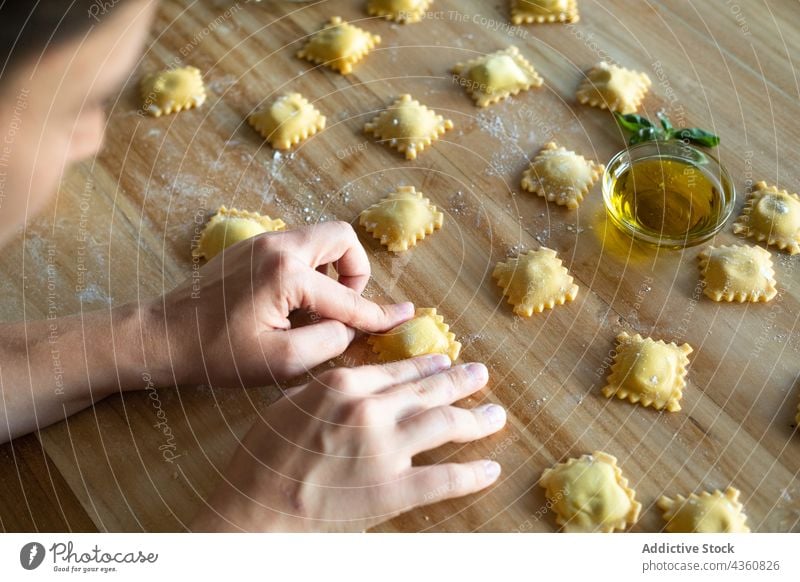 Anonyme Person bei der Zubereitung von hausgemachten Raviolis Lebensmittel Essen zubereiten Gesundheit Tisch traditionell hölzern Ernährung Nahaufnahme Spätzle