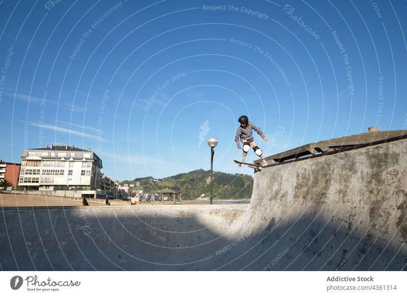 Jugendlicher Skater fährt auf einer Rampe im Skatepark Junge Skateboard Mitfahrgelegenheit Skateplatz Trick Teenager Stunt Seeküste extrem Aktivität