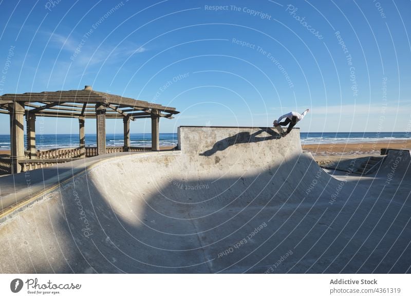 Jugendlicher Skater fährt auf einer Rampe im Skatepark Junge Skateboard Mitfahrgelegenheit Skateplatz Trick Teenager Stunt Seeküste extrem Aktivität