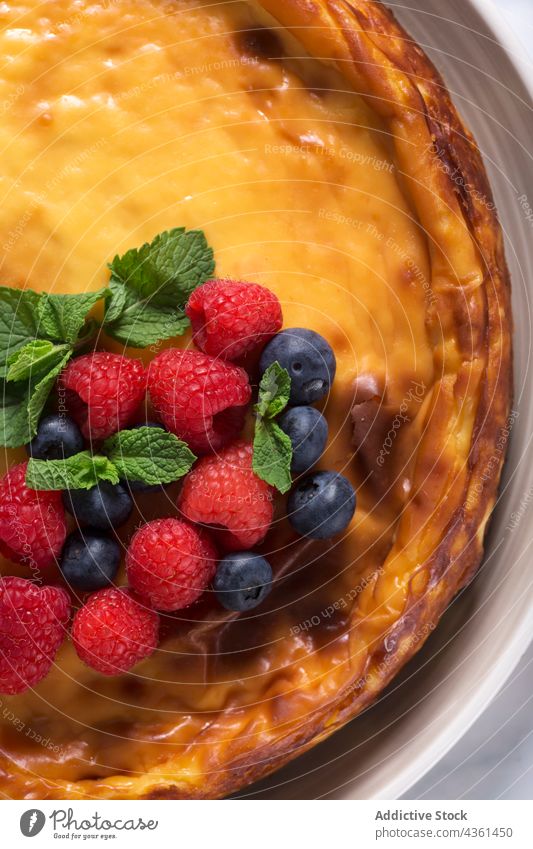 Käsekuchen mit Beeren Lebensmittel süß Dessert Overhead Draufsicht Minze Blätter Himbeeren Blaubeeren selbstgemacht Kuchen Frucht geschmackvoll Sahne frisch