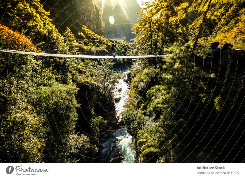 Reisende auf einer Hängebrücke über einen Fluss in den Bergen Reisender Suspension Brücke Berge u. Gebirge Steg reisen erkunden Hochland Spaziergang Himalaya