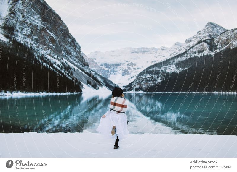 Unbekannte Frau läuft im Winter auf einen See zu laufen Ufer Berge u. Gebirge Natur Schnee kalt reisen Lake Luise Banff National Park Alberta Kanada Wasser