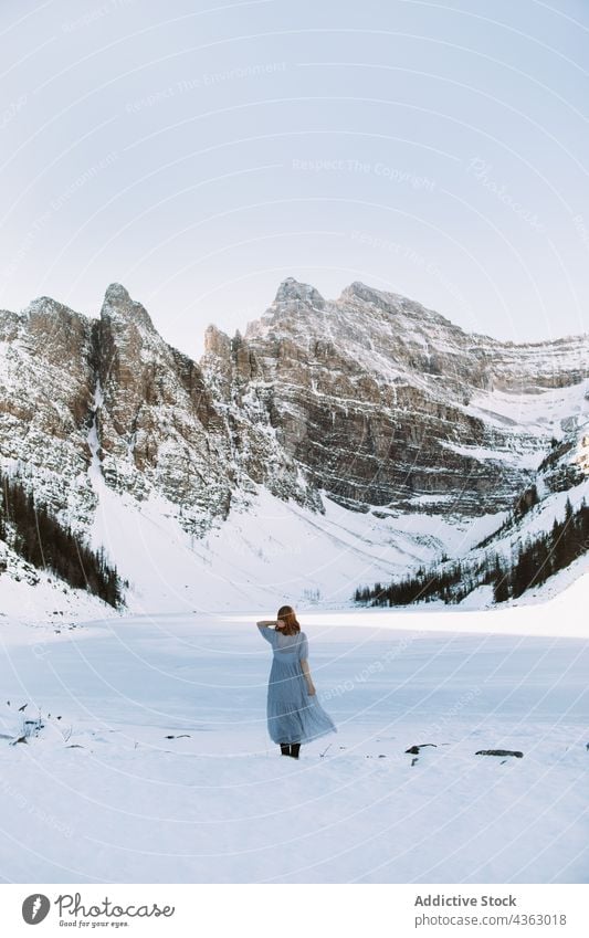 Unbekannte Frau in der Nähe eines zugefrorenen Sees im Winter Ufer Schnee Berge u. Gebirge kalt Natur Saison Lake Luise Banff National Park Alberta Kanada