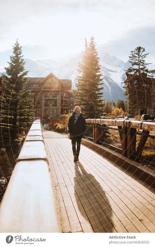 Mann bewundert Berglandschaft von Holzsteg aus Reisender Berge u. Gebirge Natur Brücke Herbst Landschaft erkunden Umwelt männlich reisen Tourismus