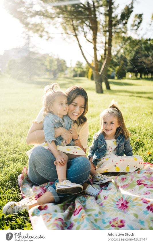 Mutter mit kleinen Töchtern ruht sich im Park aus Kind Zusammensein Sommer Geschwisterkind Liebe Glück Tochter ähnlich niedlich kuscheln Mama Partnerschaft