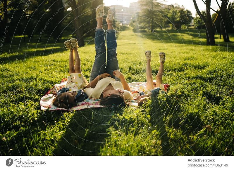 Kleine Geschwister mit Mama auf einer Decke im Park liegend Mutter Kind Zusammensein Glück Sommer Geschwisterkind Liebe Tochter ähnlich niedlich Partnerschaft