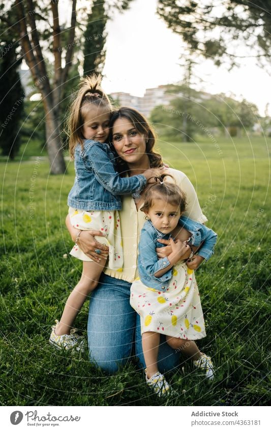 Mutter mit kleinen Töchtern ruht sich im Park aus Kind Zusammensein Sommer Geschwisterkind Liebe Glück Tochter ähnlich niedlich kuscheln Mama Partnerschaft