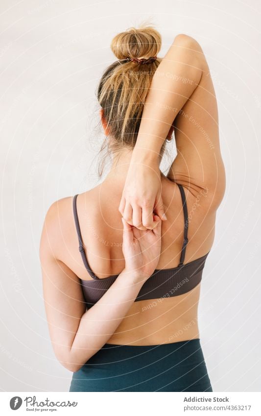 Flexible Frau beim Yoga mit Händen hinter dem Rücken Hand hinter dem Rücken Pose beweglich Dehnung üben Asana schlank passen Harmonie Gelassenheit Zen