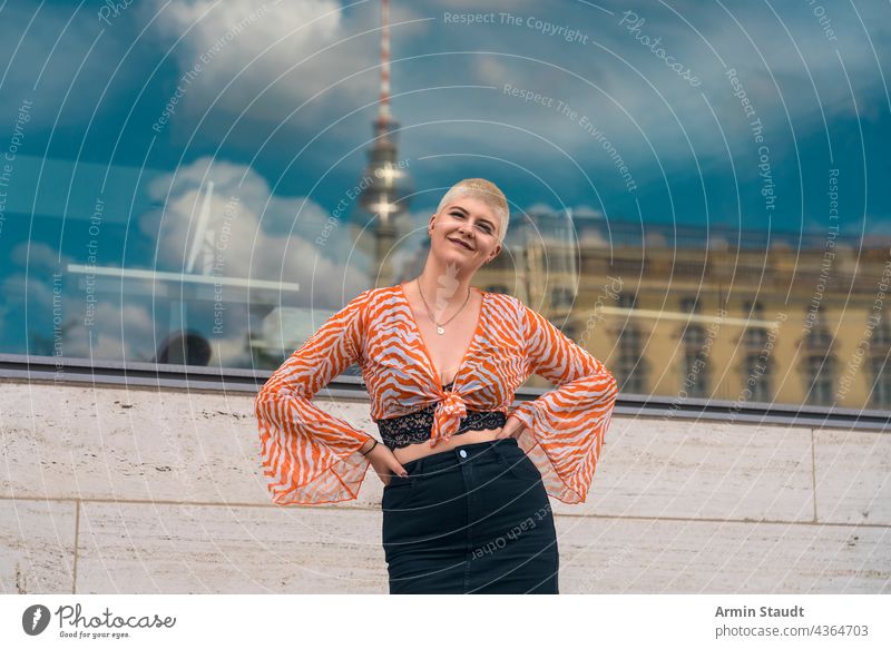 portrait einer jungen lächelnden frau mit dem berliner fernsehturm im hintergrund Frau Atelier selbstbewusst im Freien Berlin Fenster Spiegelung Stadt Großstadt