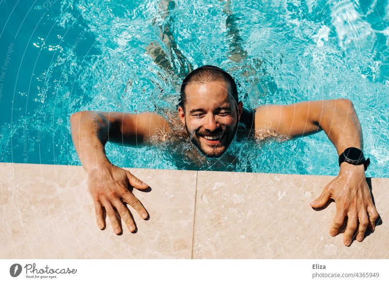 Lachender Mann stützt sich am Beckenrand eines Pools ab lachend Schwimmbad fröhlich Wasser Sommer baden planschen Sonnenschein Schwimmen & Baden Freude