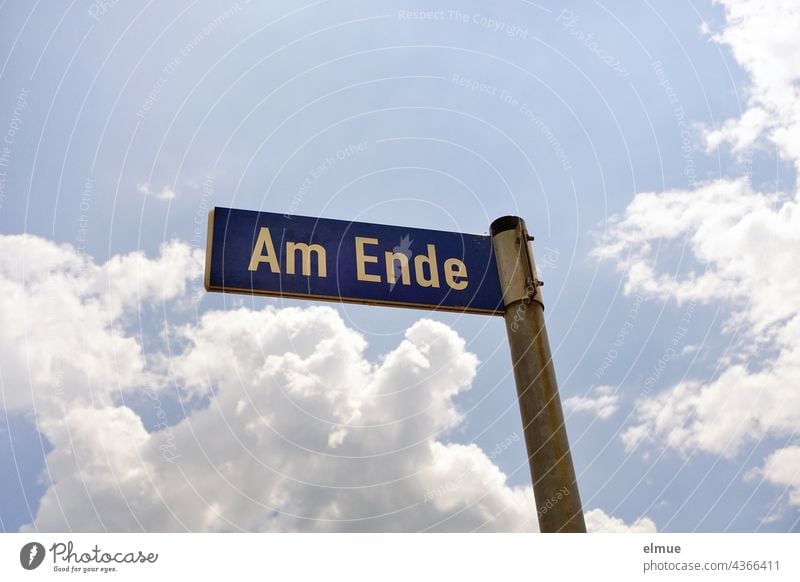 blaues Straßennamenschild  - Am Ende -  an einer Metallstange / Adresse / Straßenverzeichnis wohnen Wand Orientierung Schild Straßenbezeichnung Symbol