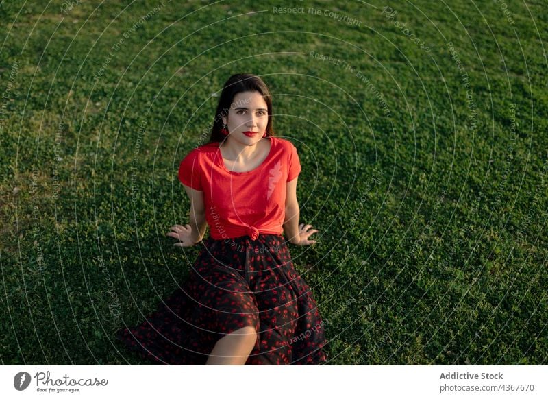 Gelassene Frau chillt auf Rasen im Park Sommer Gelassenheit Harmonie Sonnenuntergang friedlich Wiese genießen Gras Natur Feld sitzen Windstille ruhig sorgenfrei