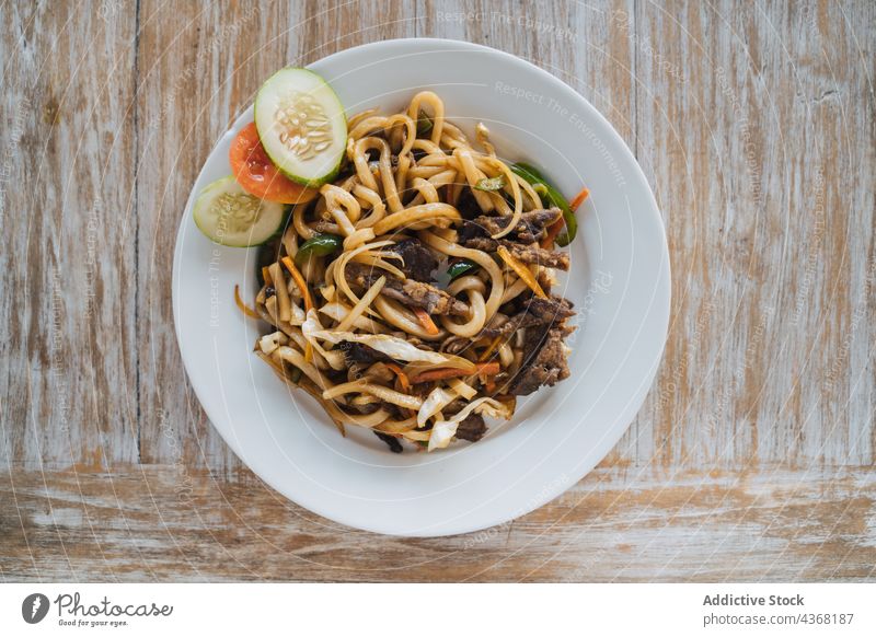 Leckere Nudeln mit Rindfleisch und frischen Gemüsescheiben Asiatische Küche Mittagessen Abendessen Mahlzeit Ernährung lecker Teller Speise geschmackvoll