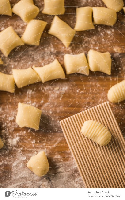 Rohe Teigstücke neben dem Rippenbrett Gnocchi Teigwaren roh Koch Tisch Holzplatte gerippt Mehl Bestandteil Küche vorbereiten Lebensmittel frisch Spätzle