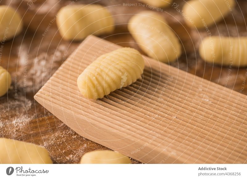 Rohe Teigstücke neben dem Rippenbrett Gnocchi Teigwaren roh Koch Tisch Holzplatte gerippt Mehl Bestandteil Küche vorbereiten Lebensmittel frisch Spätzle