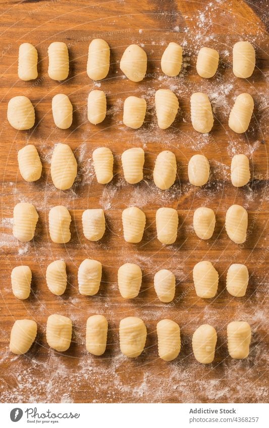 Rohe Gnocchi auf Holztisch roh Spätzle Tisch Koch Reihe Küche heimwärts Mittagessen Lebensmittel Mahlzeit vorbereiten Speise Portion kulinarisch Italienisch