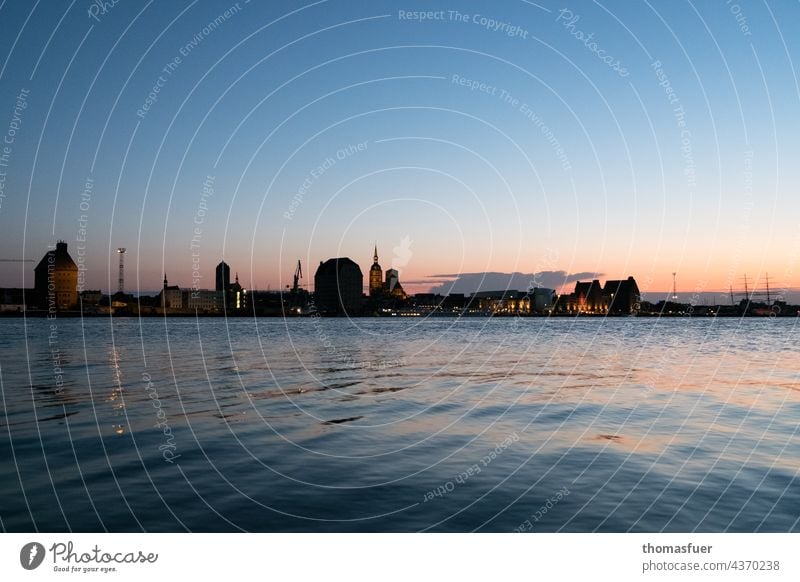 Silhouette von Hafenstadt bei Sonnenuntergang Gegenlicht Stimmung Dämmerung Abend Lichterscheinung Horizont Ruhe reisen Sommer Himmel Küste Ufer Meer Stadt