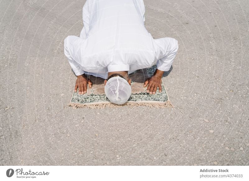 Islamischer Mann betet auf Matte am Strand muslimisch arabisch beten Religion knien Schleife Tradition Kultur Vorleger Ritual Anbetung heilig männlich ethnisch