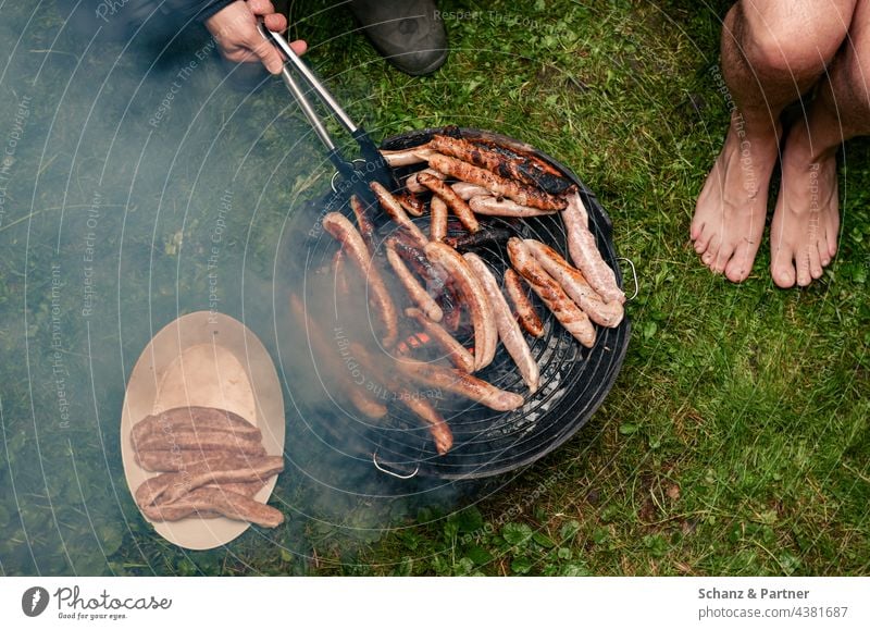 Grill voller Würstchen im Garten grillen Würste Fleisch Ernährung Wurstwaren Camping Campingplatz Rauch Außenaufnahme Bratwurst Grillrost lecker Grillsaison