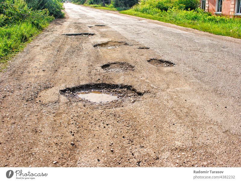 alte kaputte Straße im Dorf Konstruktion gebrochen Asphalt Boden dreckig Schaden Gefahr Golfloch Autobahn reisen Schlagloch rau Weg schwarz Hintergrund Fahrspur