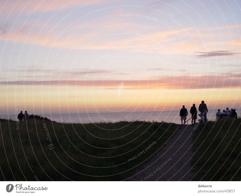 Menschen, die auf der Spitze der Dünen stehen und den Sonnenuntergang über dem Meer betrachten. Publikum Wolken Ferien & Urlaub & Reisen Windstille Himmel