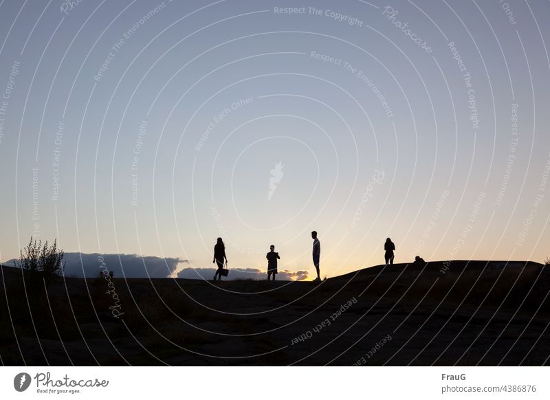 Beim Sonnenuntergang auf dem Felsen Abends Abendhimmel Himmel Wolken Menschen Sommer Frau Mann Junge Handtasche Silhouetten