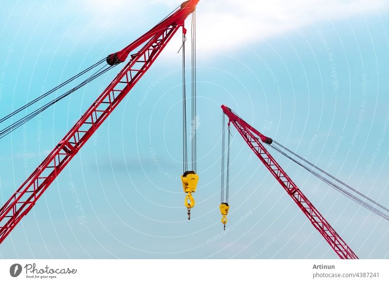 Raupenkran gegen blauen Himmel und weiße Wolken. Immobilien-Industrie. Red Raupenkran Verwendung Haspel heben Ausrüstung in Baustelle. Kran zu vermieten. Kran-Händler für Baugeschäft.