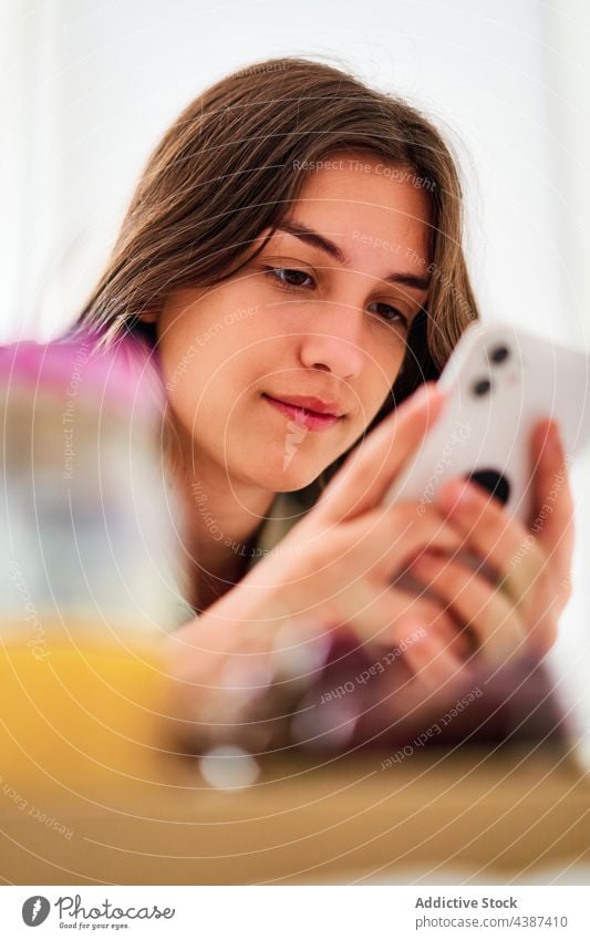 Junge Frau benutzt Smartphone beim Frühstück benutzend zu Hause Morgen online Browsen Internet Kommunizieren jung Schüler Mobile Apparatur Gerät Telefon Surfen